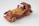 A handcrafted wooden toy car featuring a classic design with exposed fenders, open-top, and a retro style. The wood grain is visible, alternating between light and dark tones, with intricate details on headlights and wheels.
