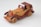 A handcrafted wooden toy car featuring a classic design with exposed fenders, open-top, and a retro style. The wood grain is visible, alternating between light and dark tones, with intricate details on headlights and wheels.