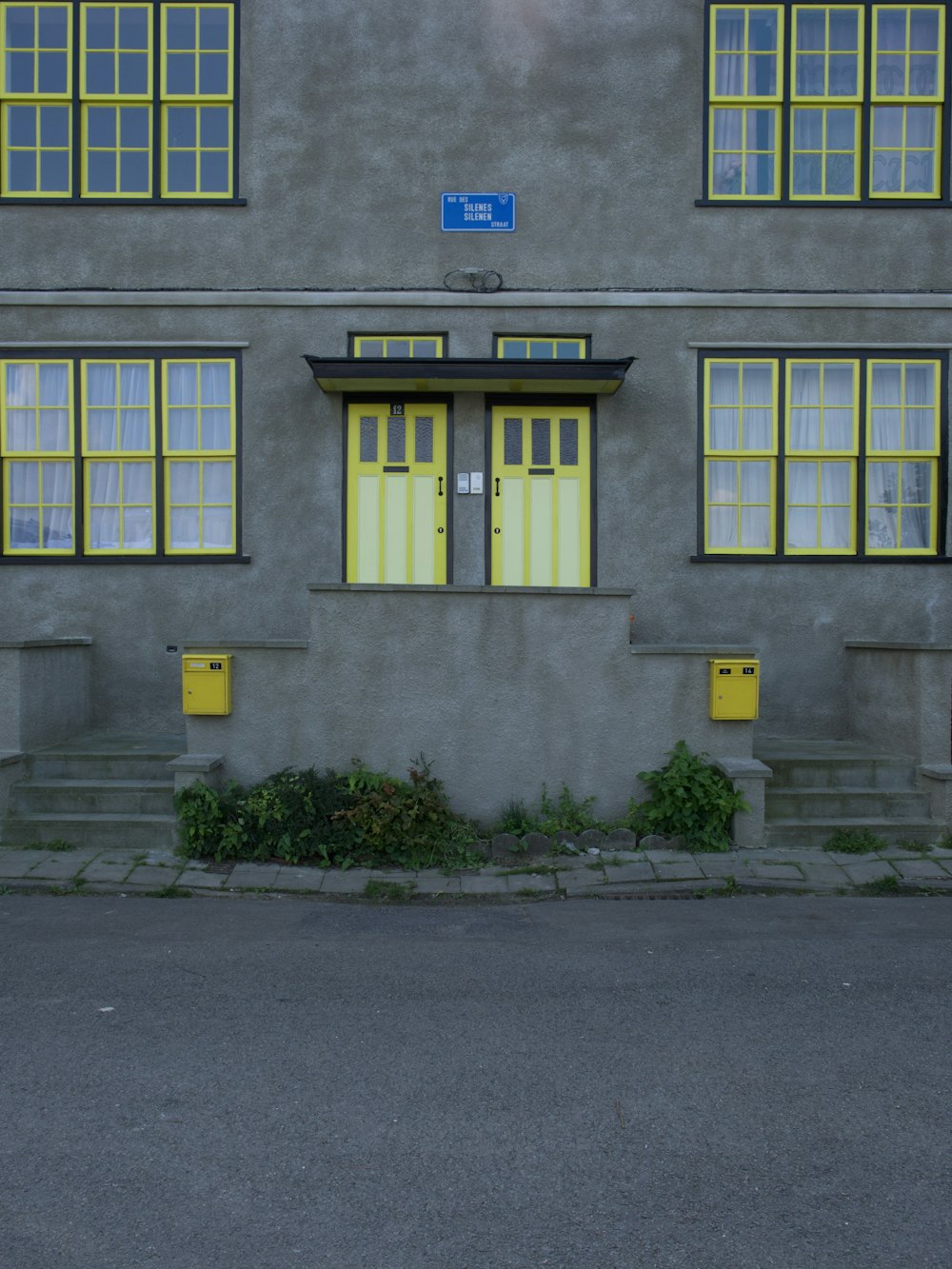 grey concrete building with blue wooden door