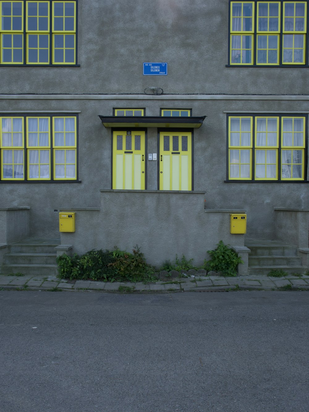 Edificio in cemento grigio con porta in legno blu