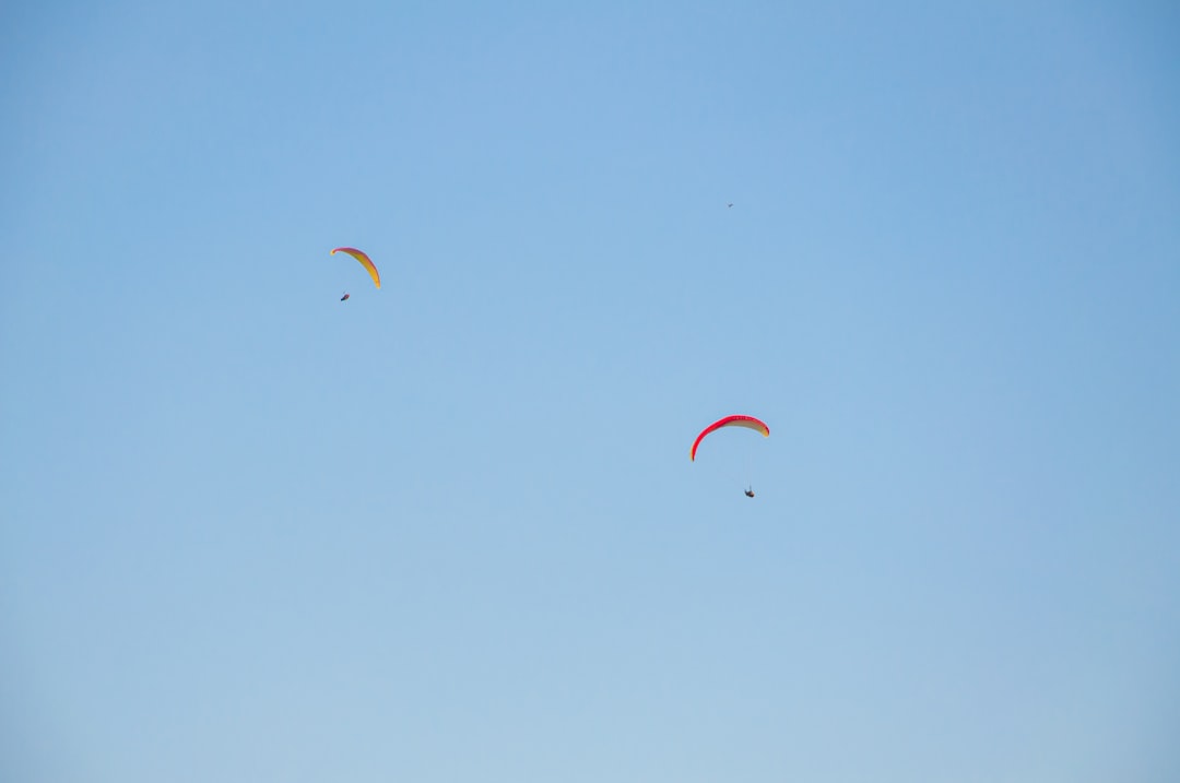 people in the sky with red and yellow parachute