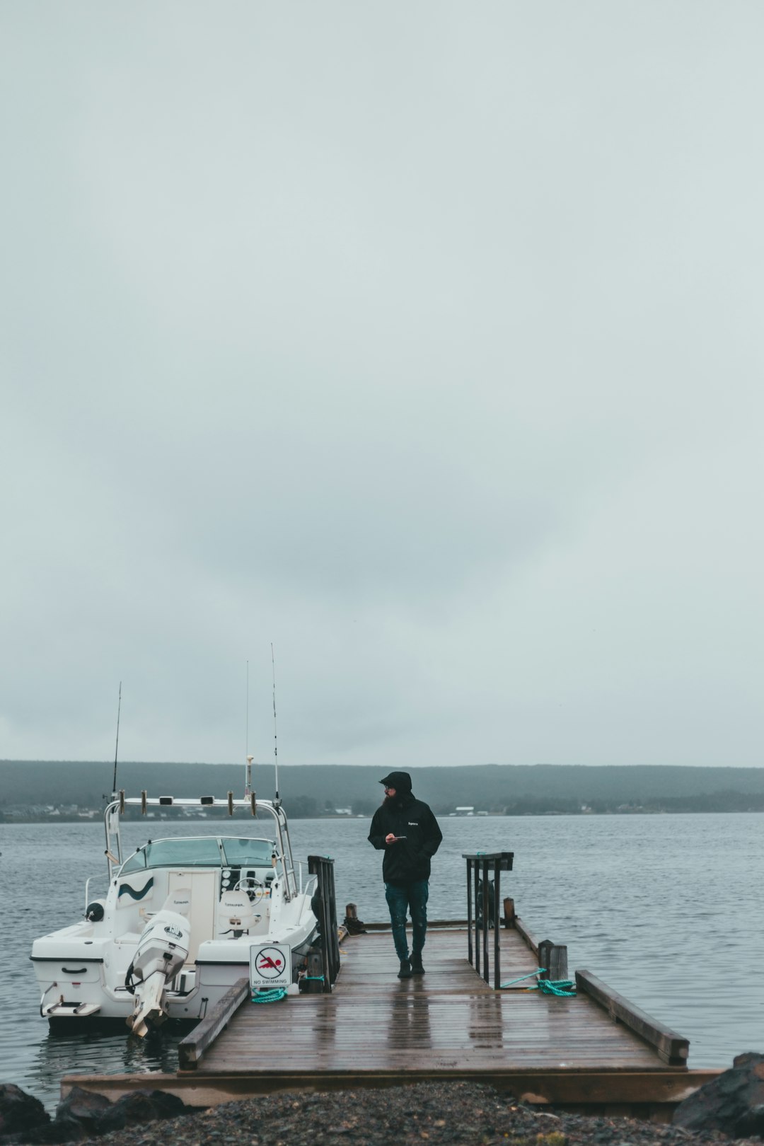 man in black jacket standing on boat during daytime