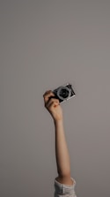 person holding black and silver camera