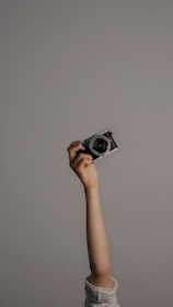 person holding black and silver camera
