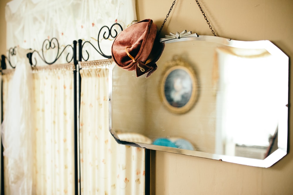 brown leather sling bag hanging on white wooden door