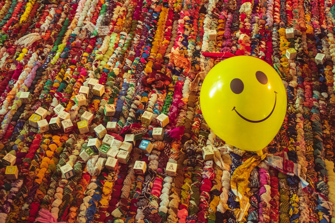 yellow smiley balloon on assorted color textile