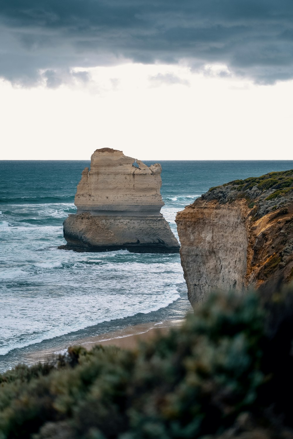 brown rock formation on sea under white sky during daytime