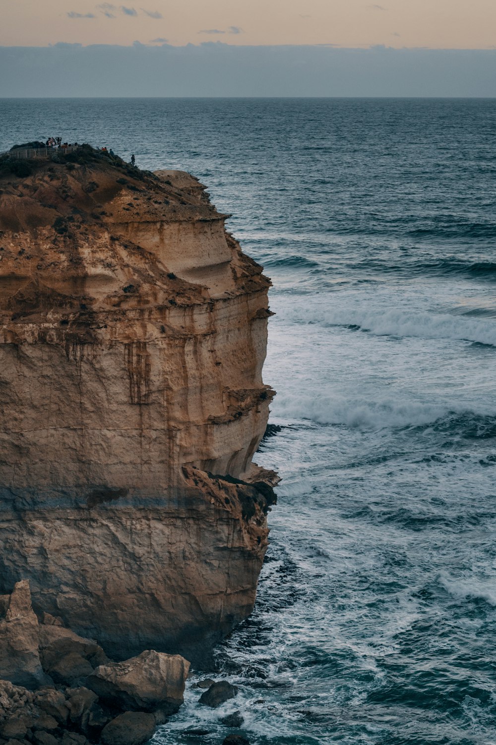 brown rock formation beside body of water during daytime