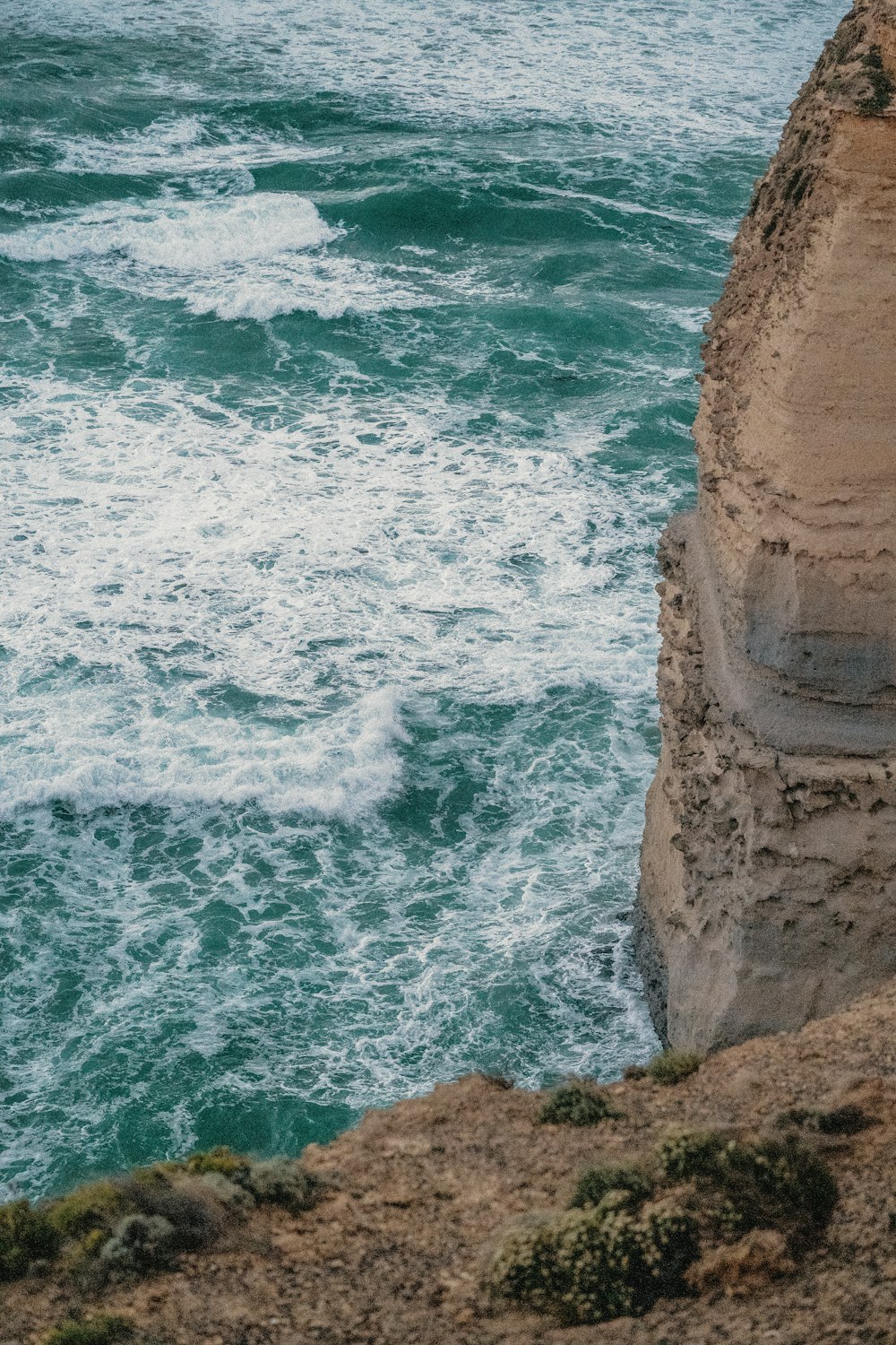 brown rock formation beside body of water during daytime