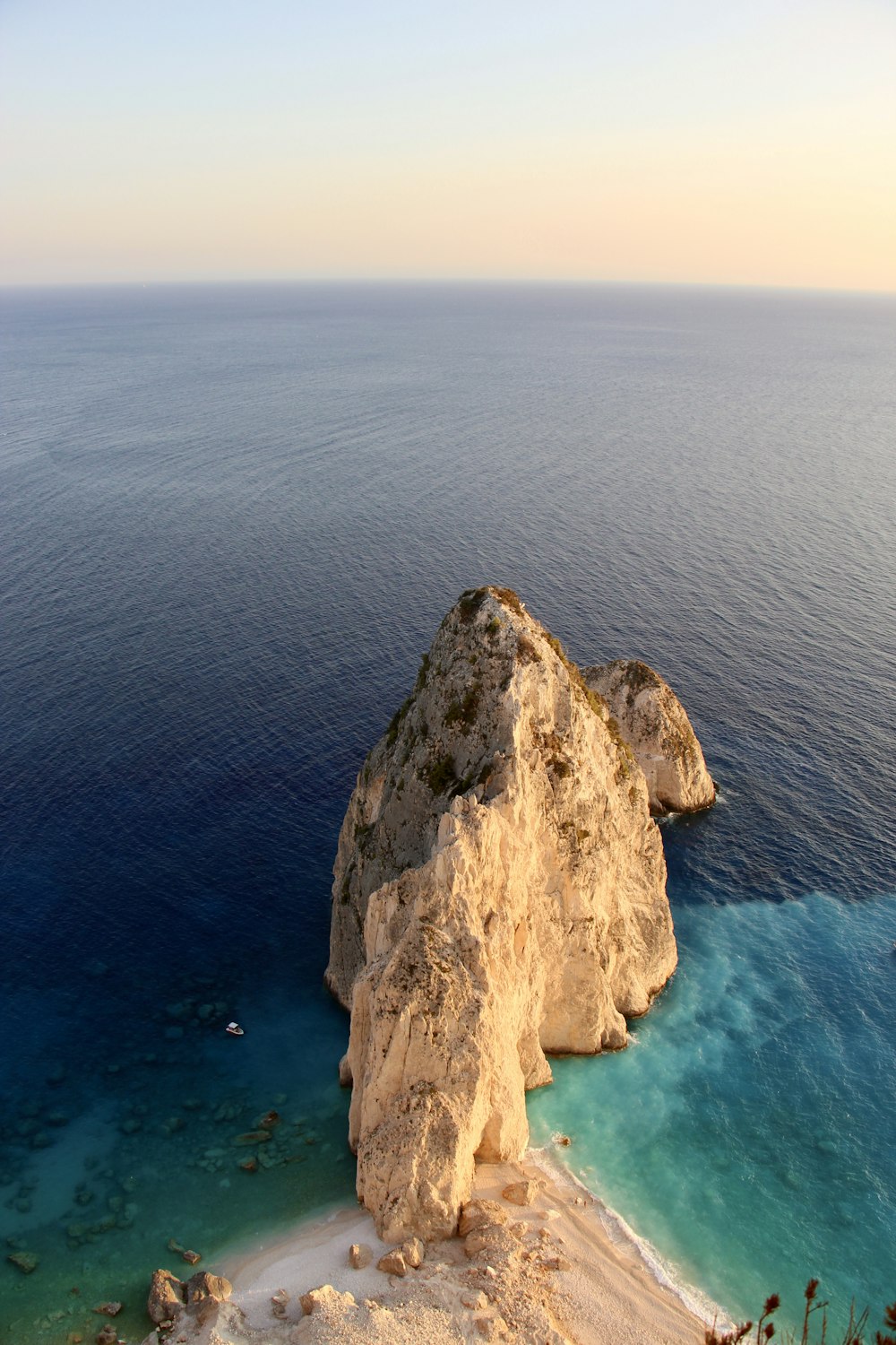 brown rock formation on body of water during daytime