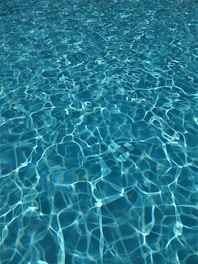 person swimming on the sea during daytime