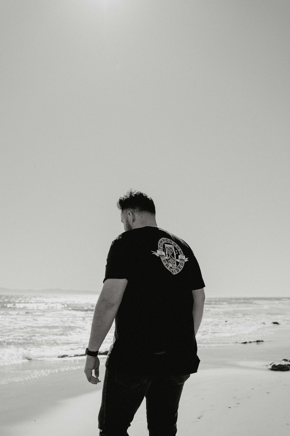 man in black t-shirt standing on beach during daytime