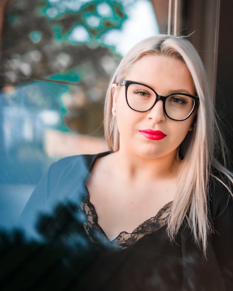 Woman in sunglasses taking a selfie and making a peace sign