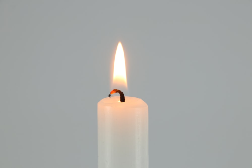white pillar candle on white surface