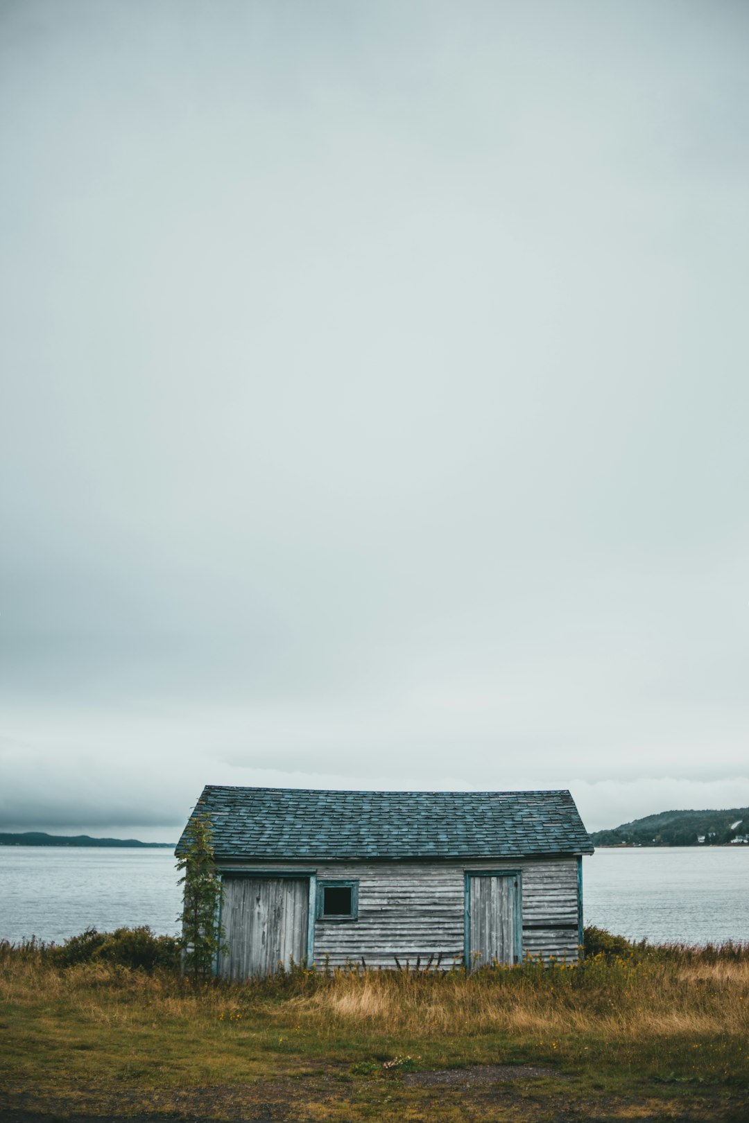 brown wooden house on body of water under white sky during daytime