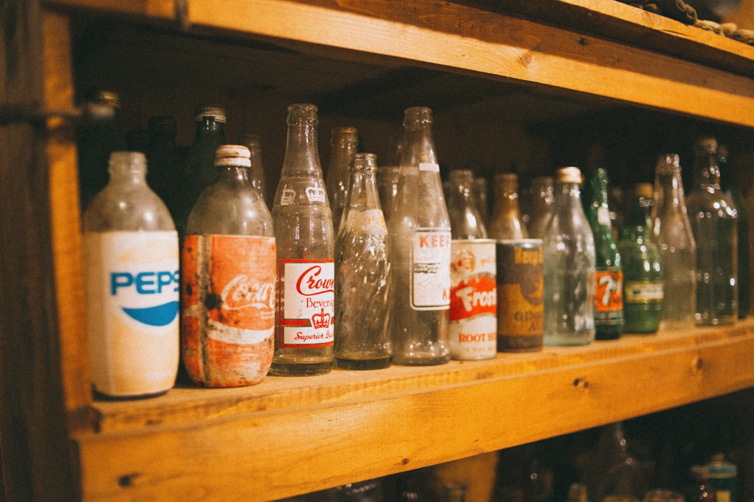 coca cola bottles on brown wooden shelf