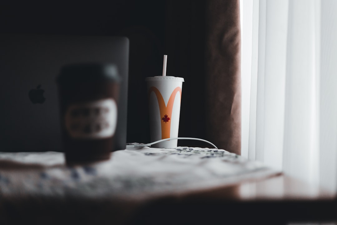 white and orange disposable cup on white table