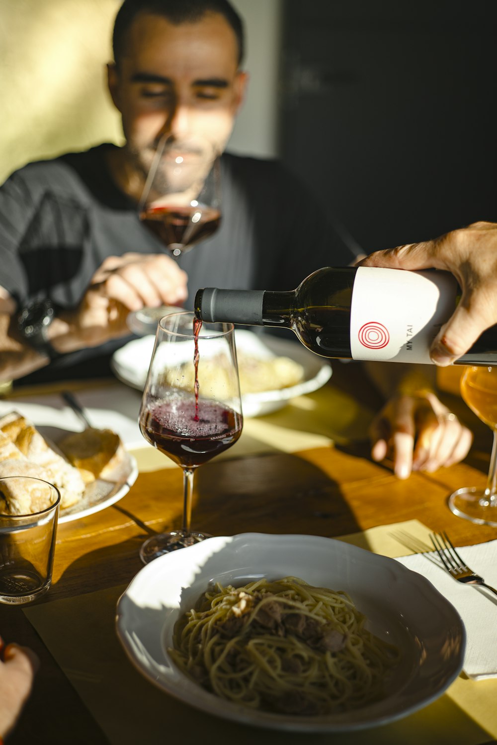 person pouring wine on wine glass