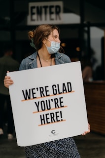 woman in blue denim jacket holding white paper