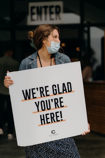 woman in blue denim jacket holding white paper