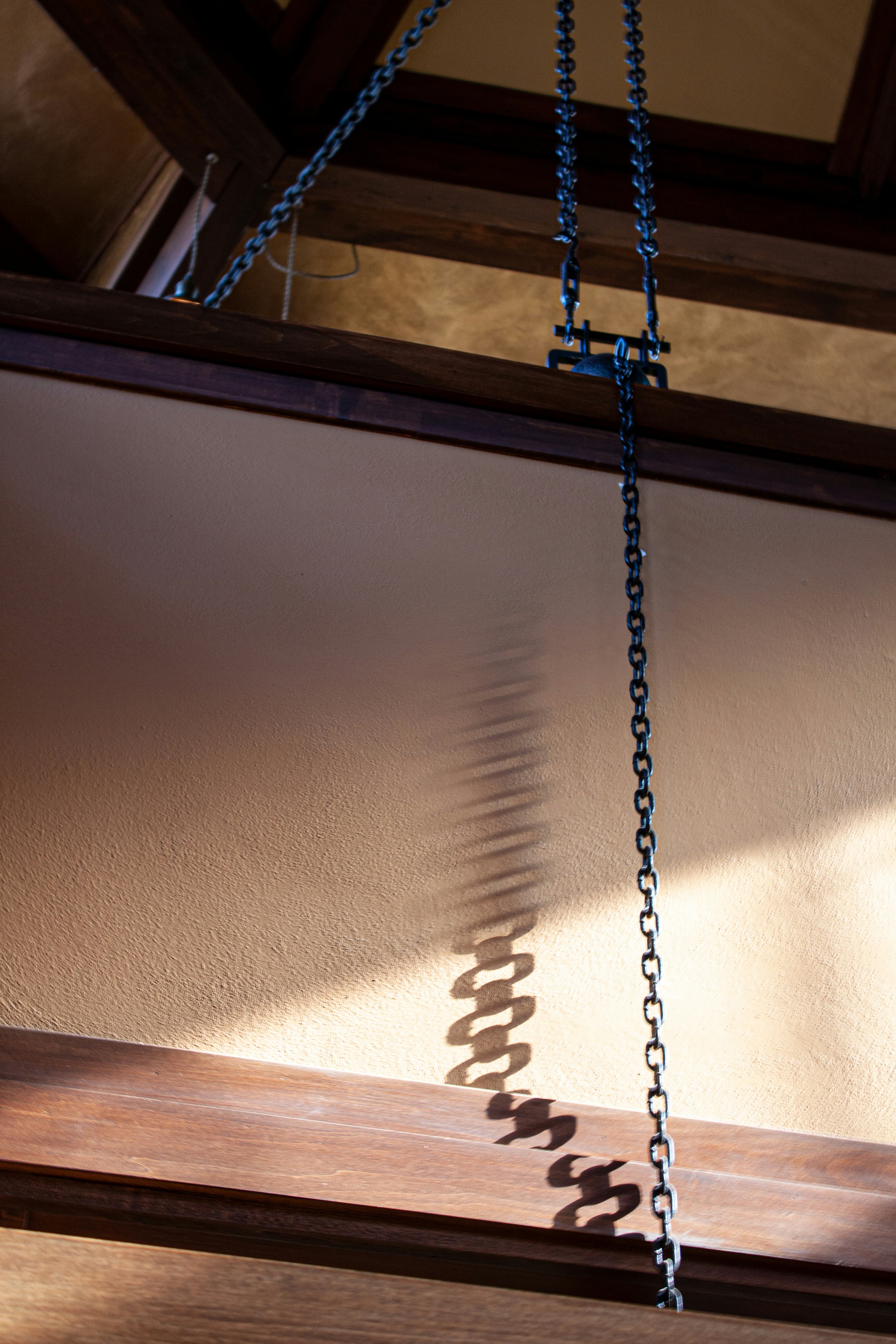 silver chain necklace on white window blinds