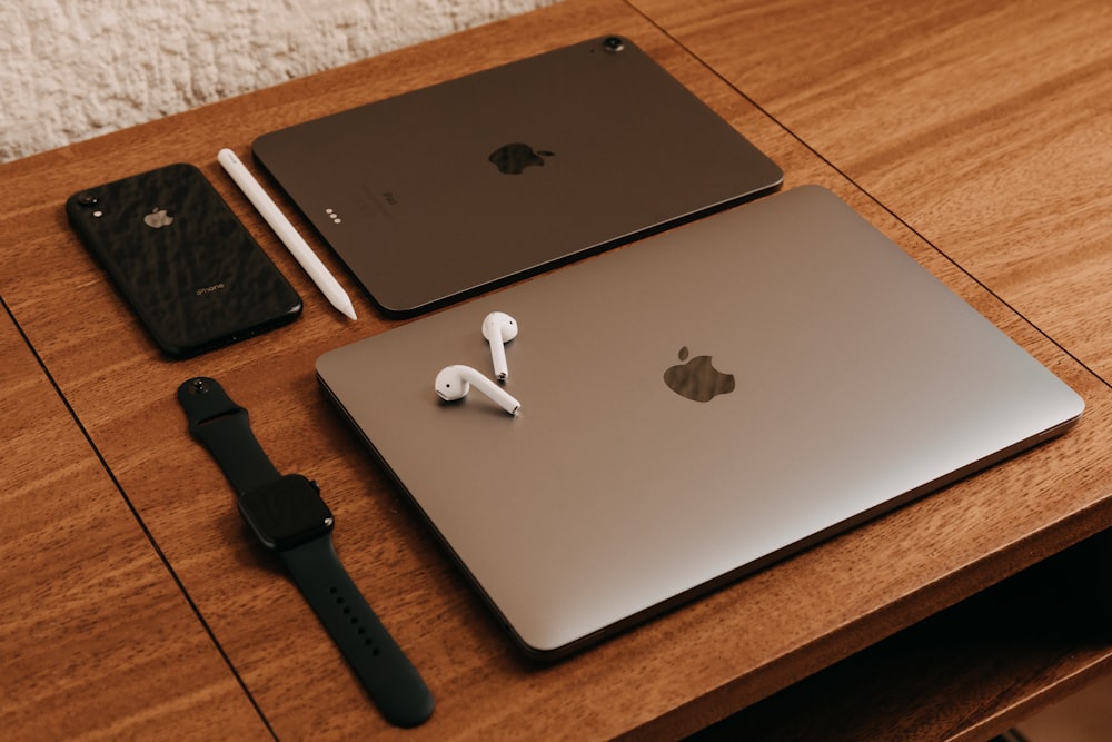 silver macbook beside black apple watch