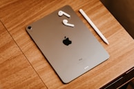 silver ipad on brown wooden table