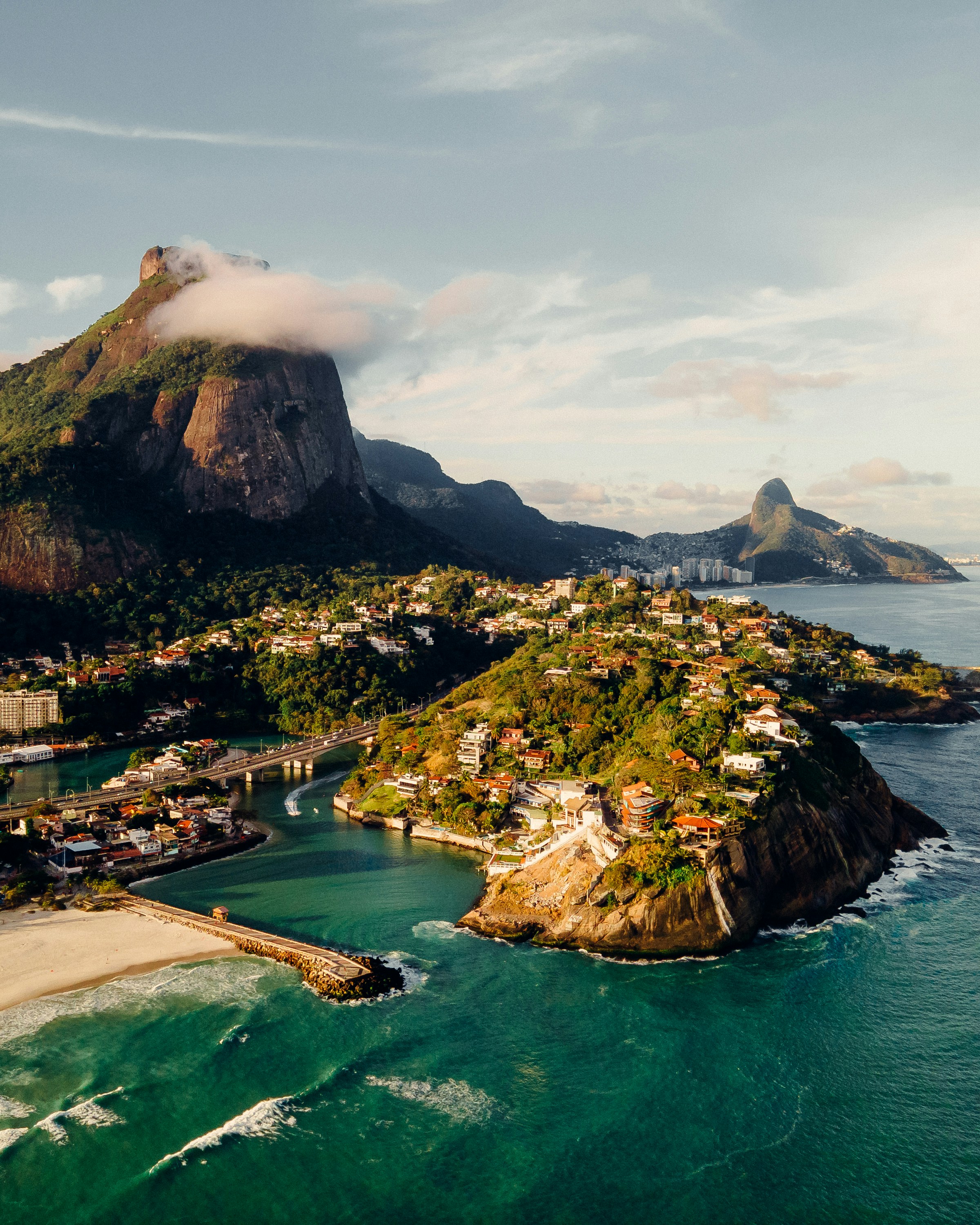green and brown mountain beside body of water during daytime