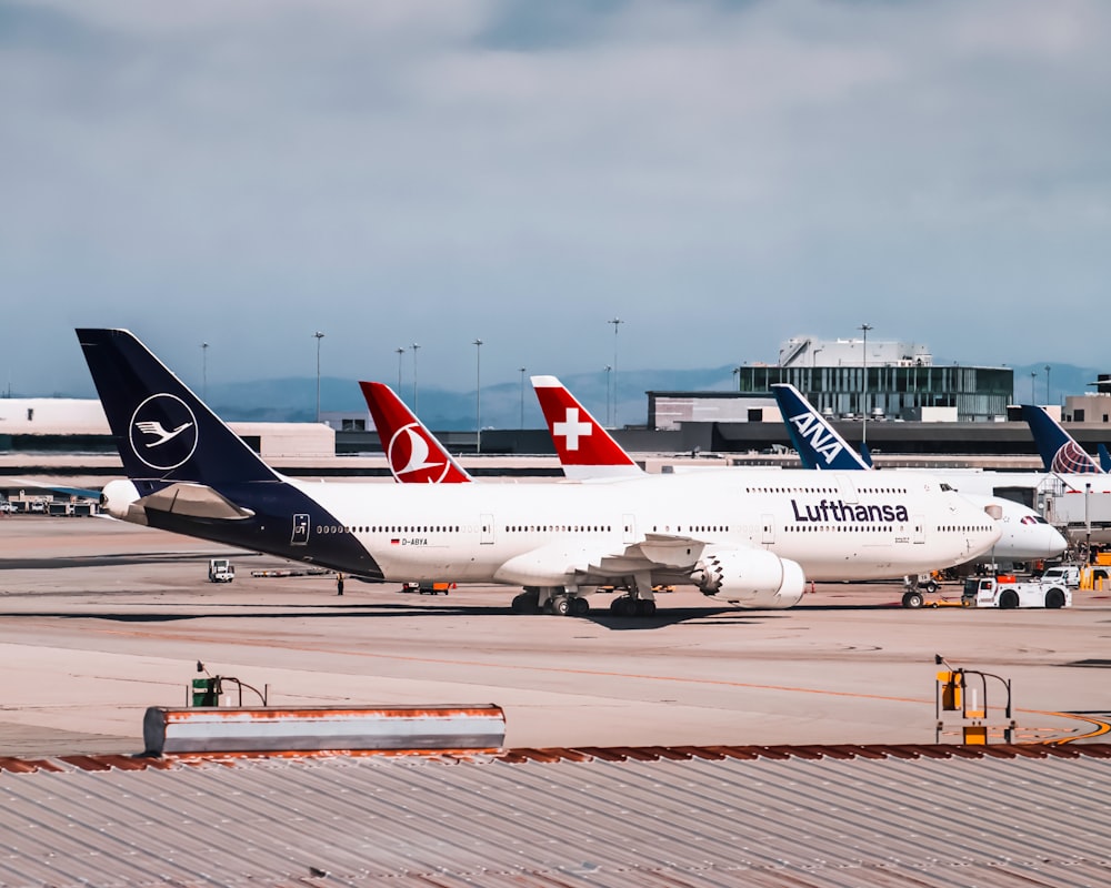 white and red passenger plane on airport during daytime