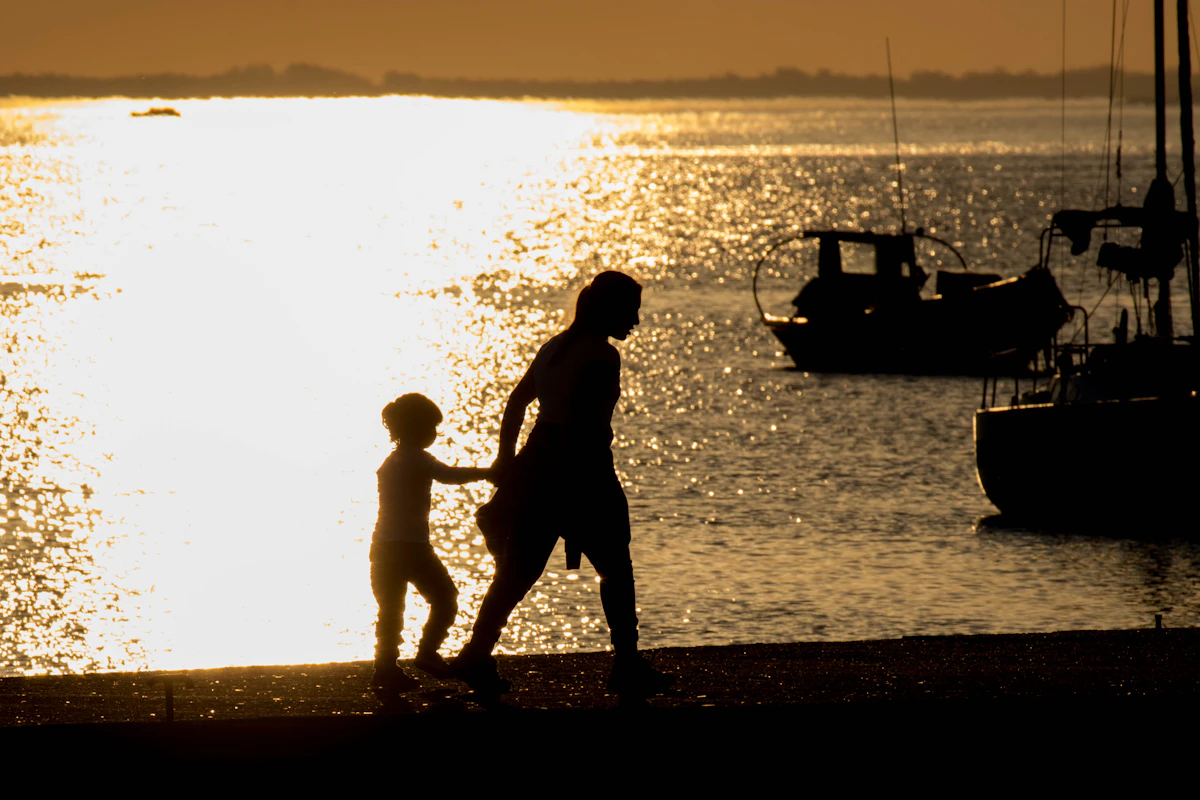 Two children on the beach at sunset