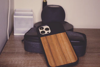 A rustic wooden phone stand displayed on a desk, crafted from reclaimed wood with visible grain patterns.