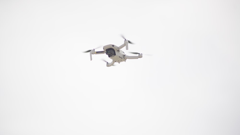 white and black drone flying