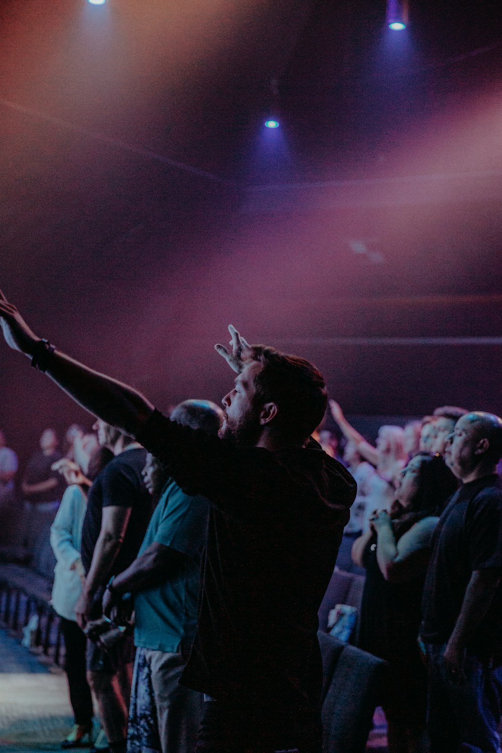 man in black shirt raising his hands