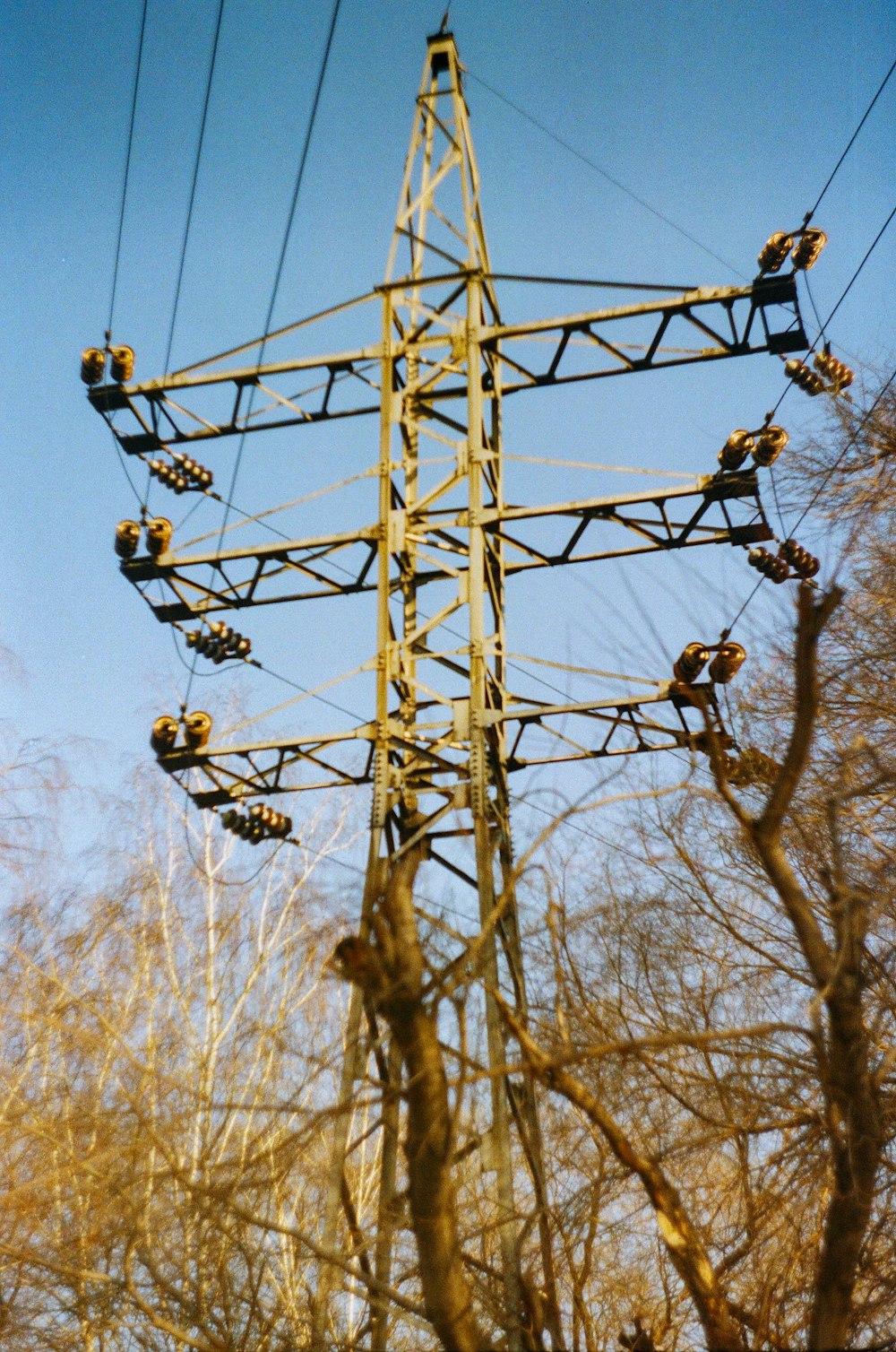 brown electric post under blue sky during daytime