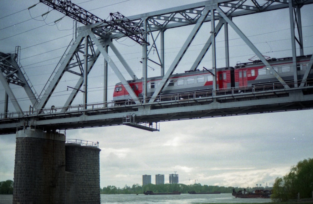red and white train on rail bridge during daytime