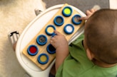 A curious child exploring a sensory toy with bright textures.