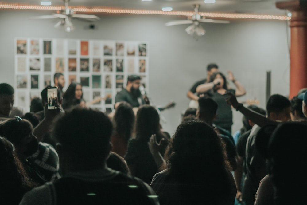 man in black shirt singing on stage