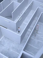 man in white shirt and black pants standing on white staircase