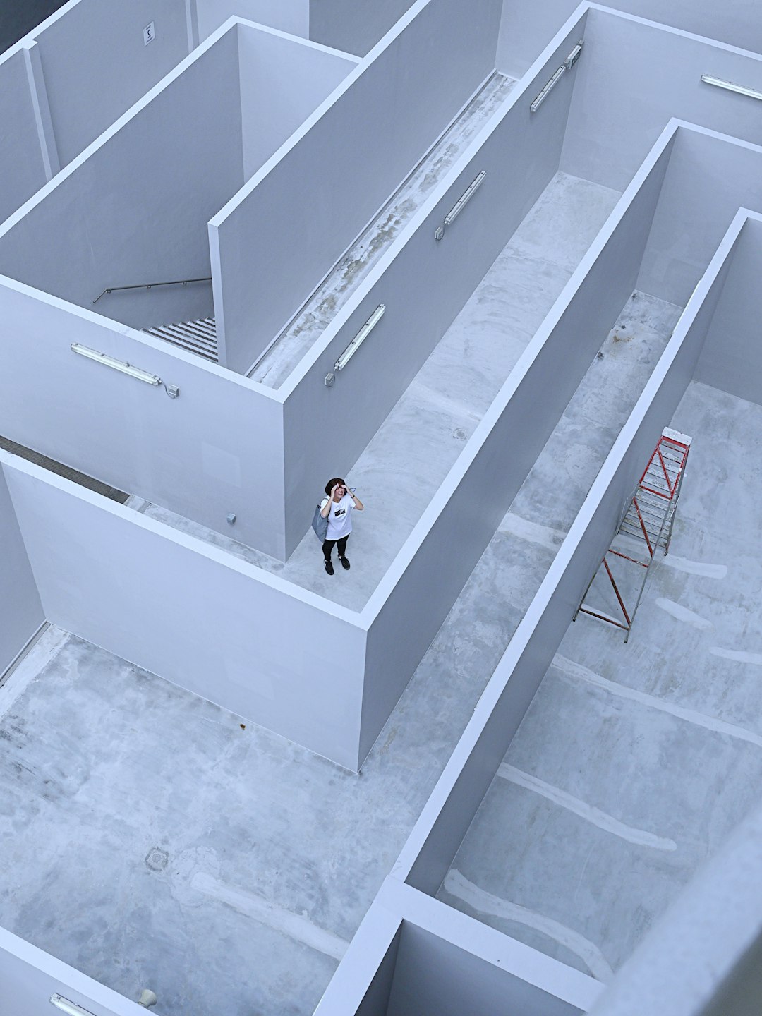 man in white shirt and black pants standing on white staircase