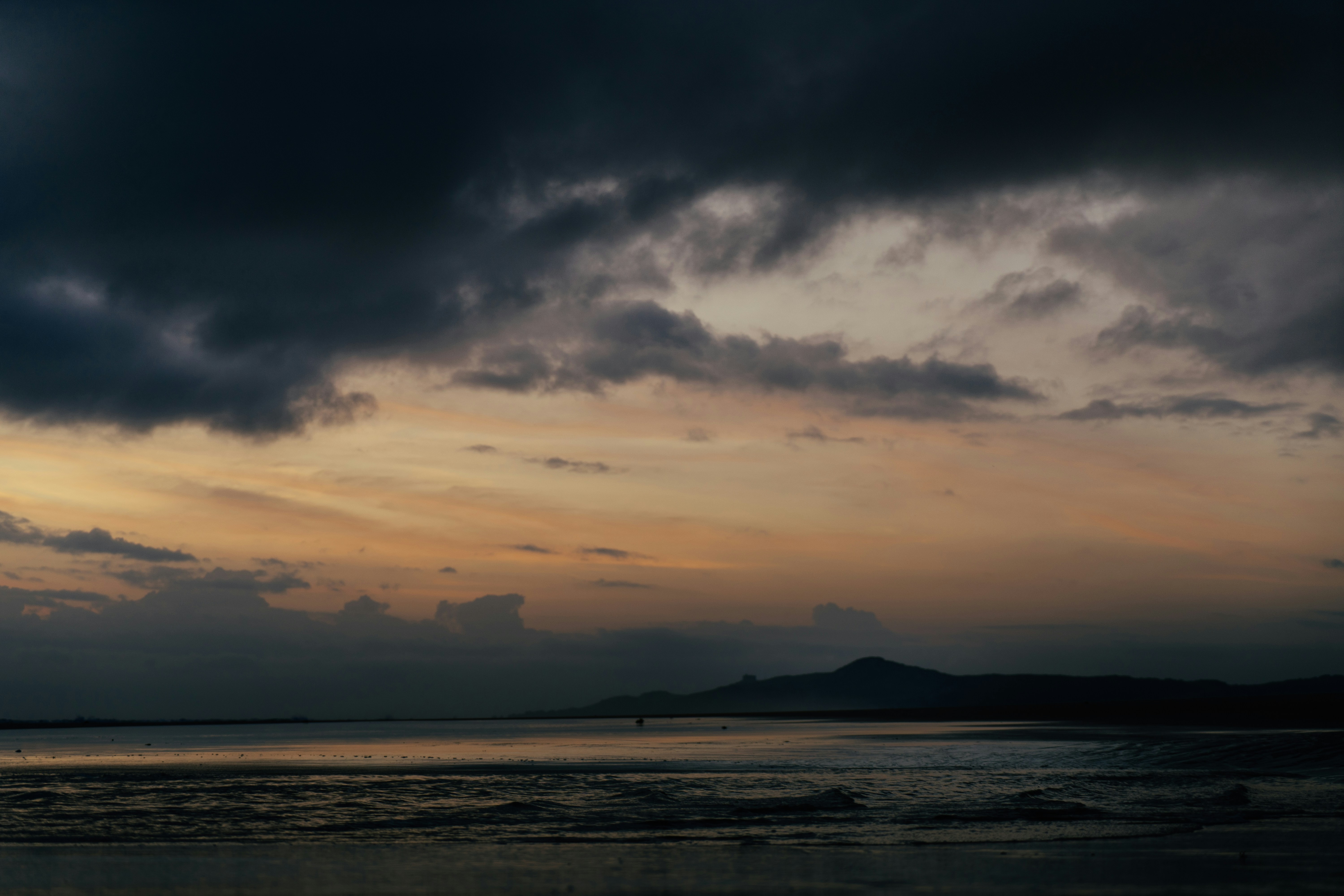 body of water under cloudy sky during daytime