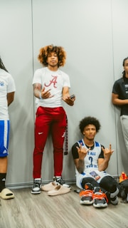 Two young men wearing retro football jerseys: one in a classic Argentina shirt with Nike pants, the other in a vintage Boca Juniors jersey paired with retro Adidas pants, standing side by side in an urban setting.