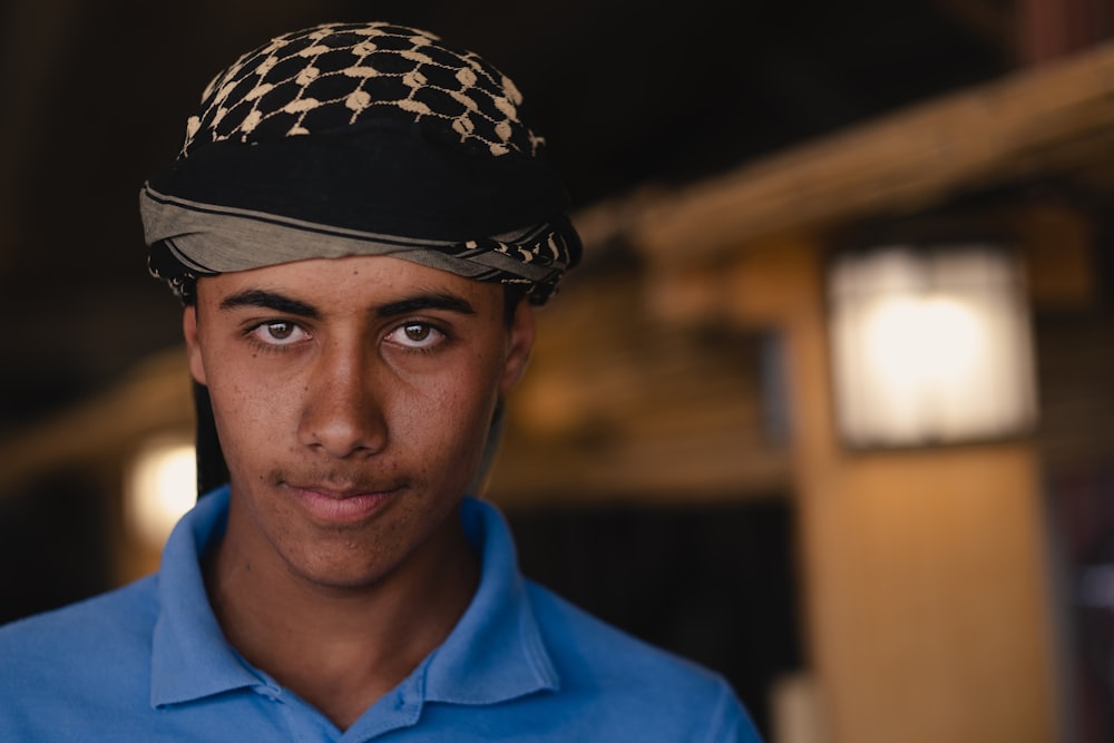 Homme en polo bleu portant un chapeau noir et blanc