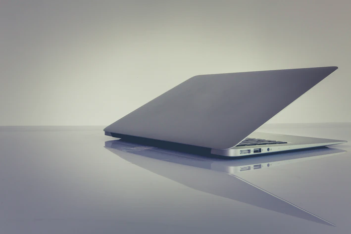 A sleek refurbished laptop open on a modern desk with soft lighting highlighting its premium build.