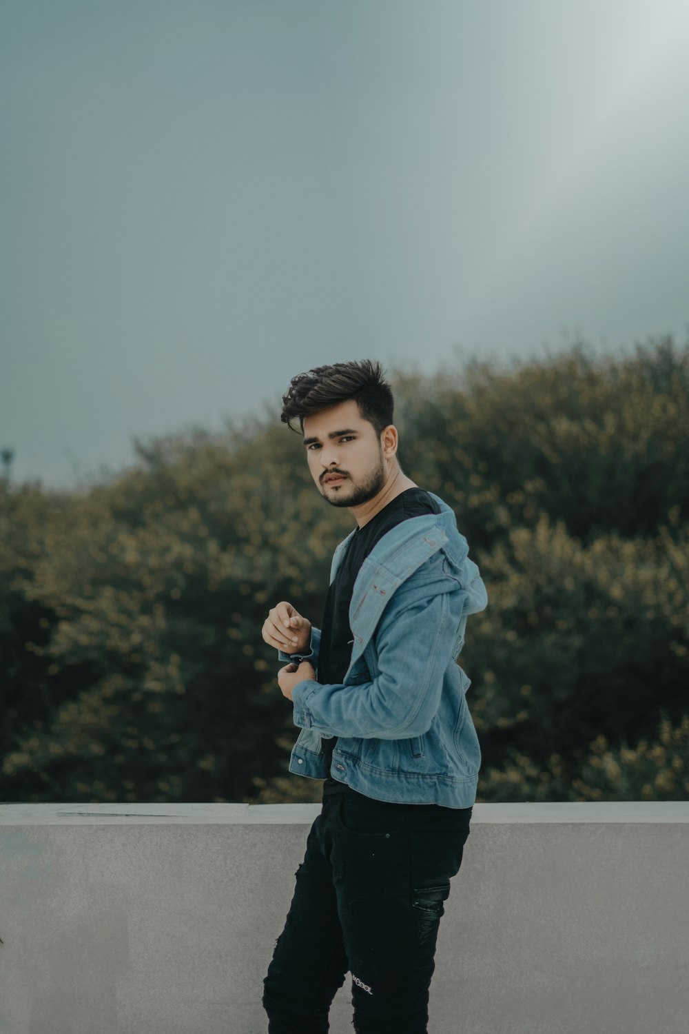 boy in blue jacket standing on road during daytime