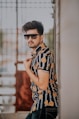 woman in black and yellow floral sleeveless dress wearing black sunglasses