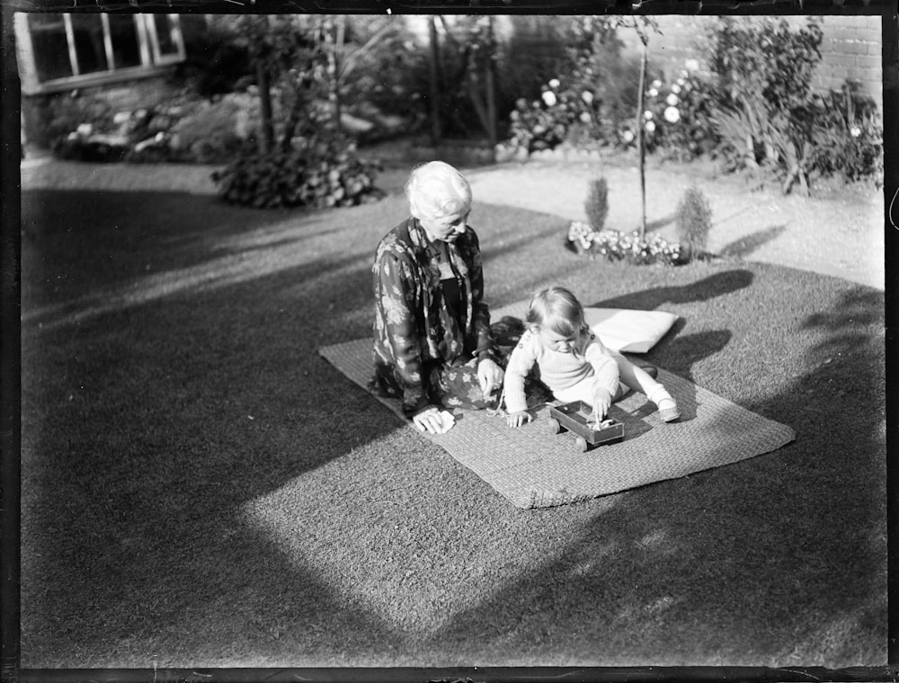 2 niños sentados en el suelo en fotografía en escala de grises