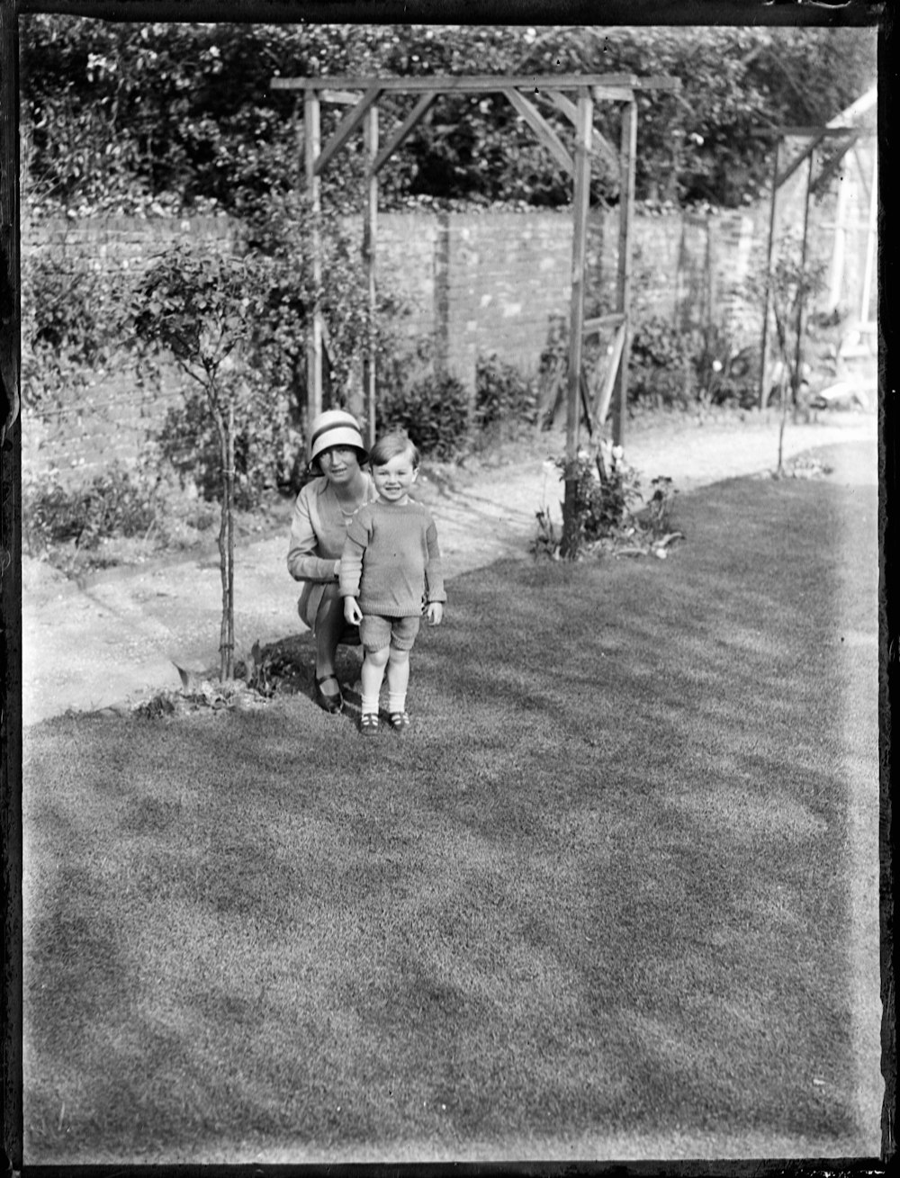 grayscale photo of man in jacket and helmet holding stick