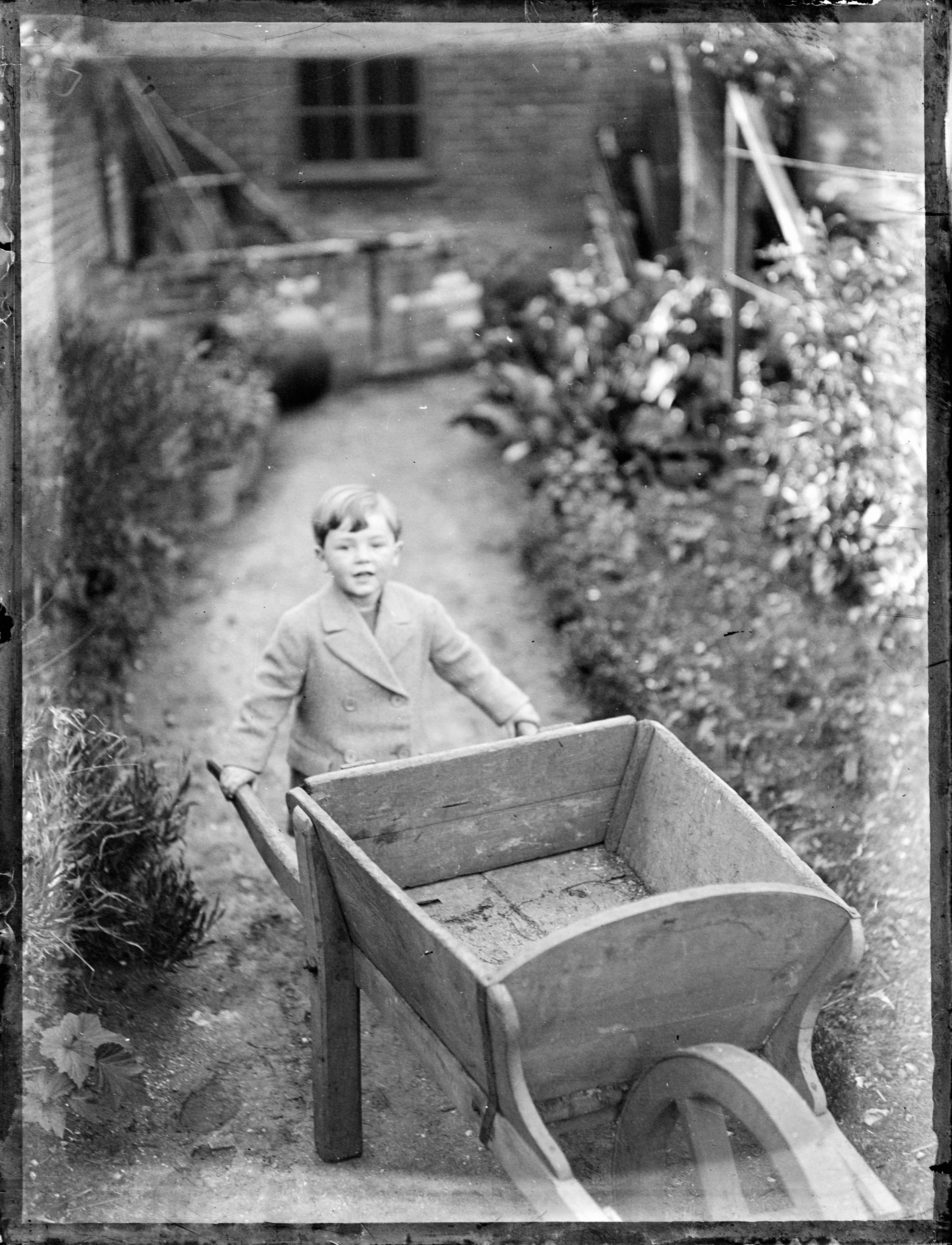 Photo en niveaux de gris d’un enfant dans une caisse en plastique