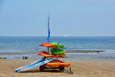 blue and orange kayak on beach during daytime