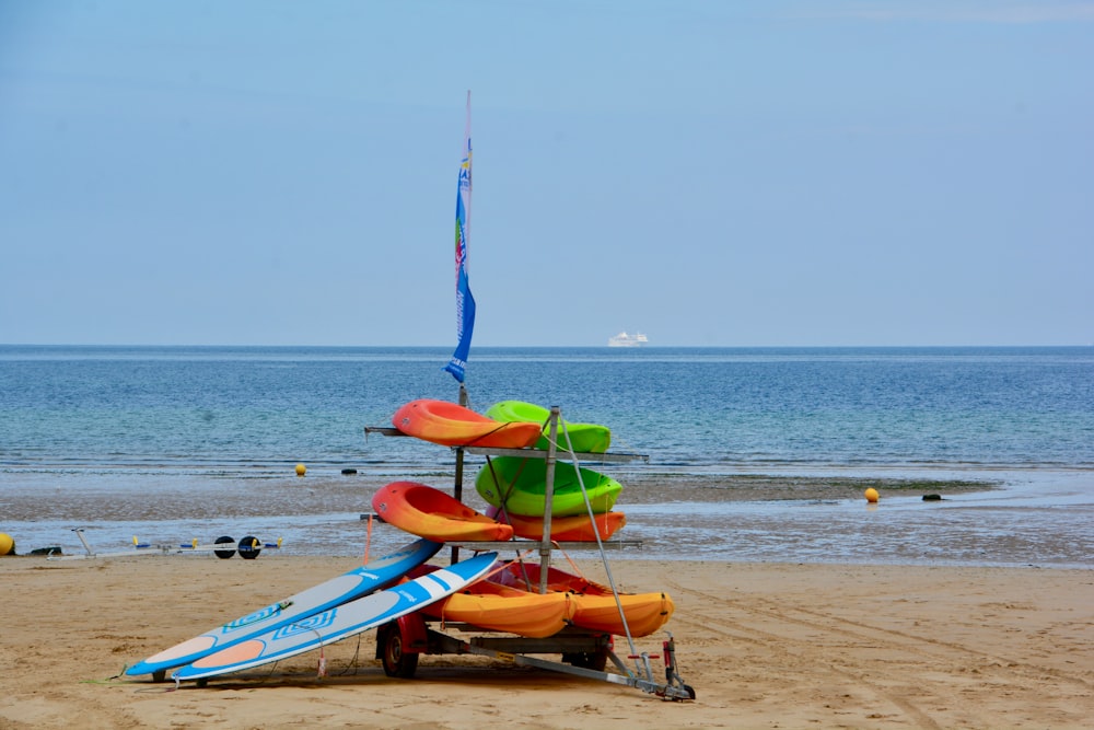 blue and orange kayak on beach during daytime